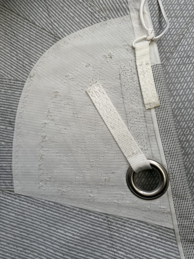 This photo shows a Leech reef cringle, note the Dimension-Polyant Hydranet reinforcement on leech and splayed dyneema webbing on cringle.