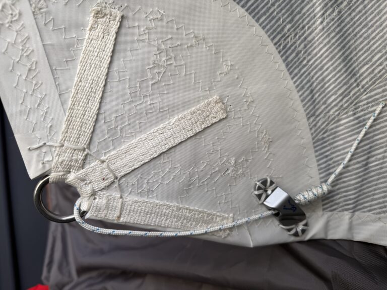 Tack with cutaway to meet mast gate height, showing cam cleat hand stitching and reverse foot line for ease of use.